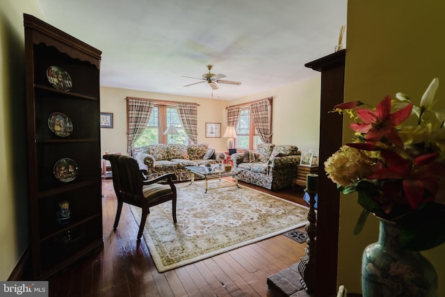 living room featuring ceiling fan and dark wood-type flooring