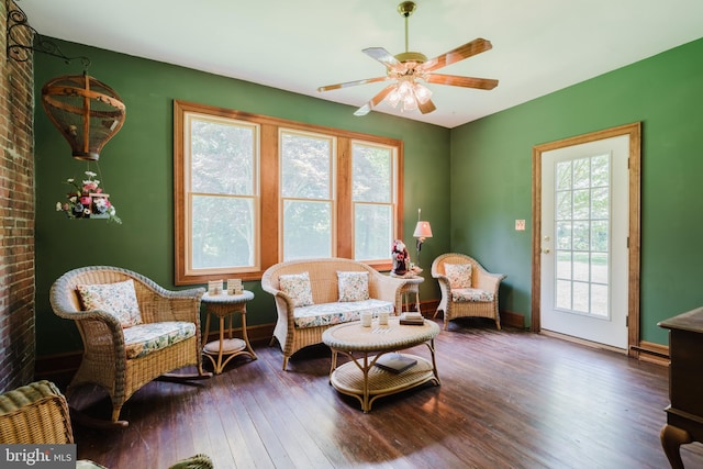 living area with dark hardwood / wood-style flooring, ceiling fan, and plenty of natural light