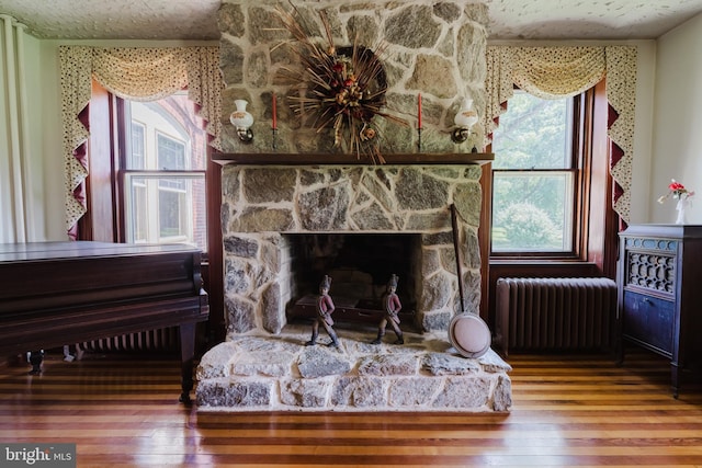 details with hardwood / wood-style flooring, a fireplace, and radiator