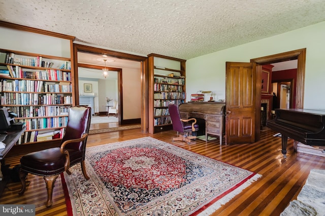 office area with a textured ceiling, hardwood / wood-style flooring, and vaulted ceiling