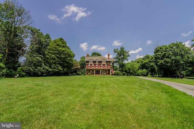 view of front of home with a wooden deck and a front lawn