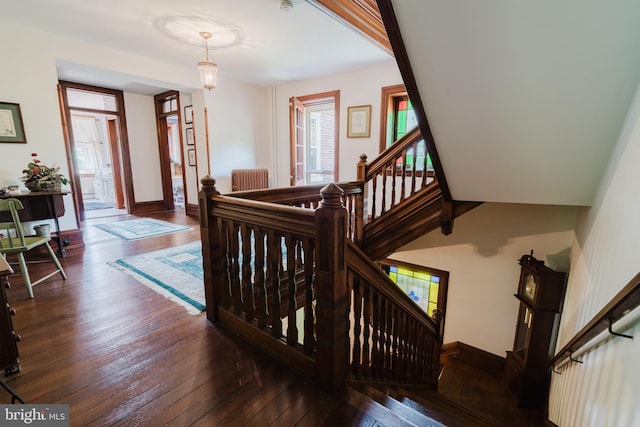 stairs featuring wood-type flooring and radiator heating unit