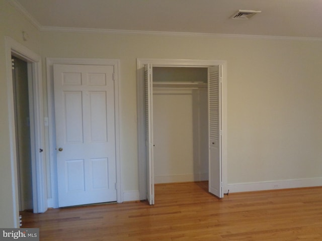 unfurnished bedroom featuring light wood-type flooring and ornamental molding