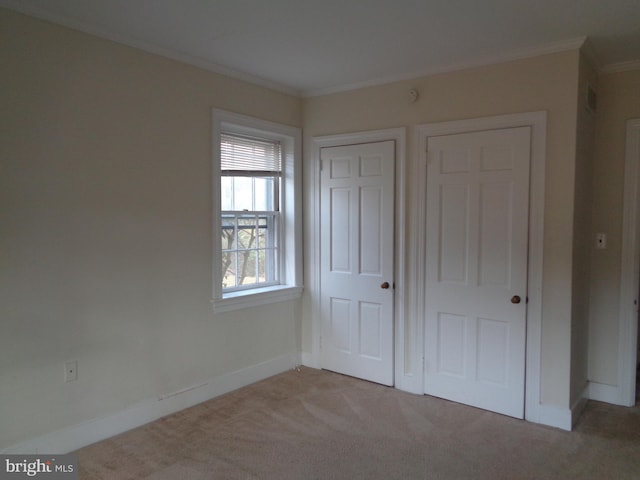 unfurnished bedroom featuring light carpet and crown molding