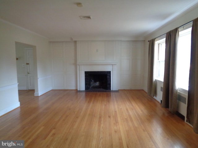 unfurnished living room featuring light hardwood / wood-style floors and radiator