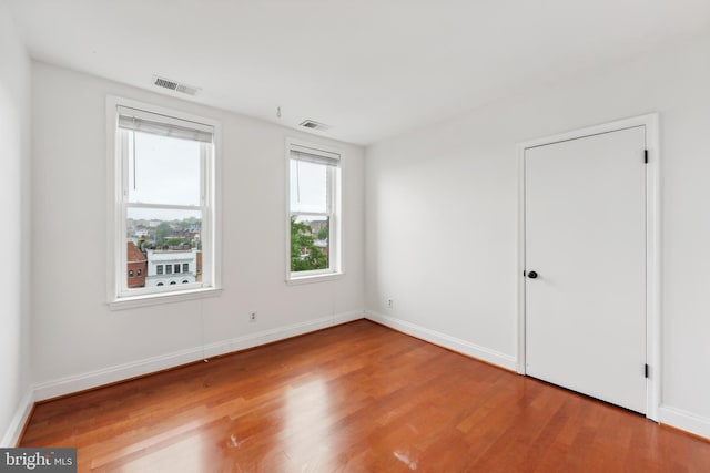 unfurnished room with hardwood / wood-style flooring