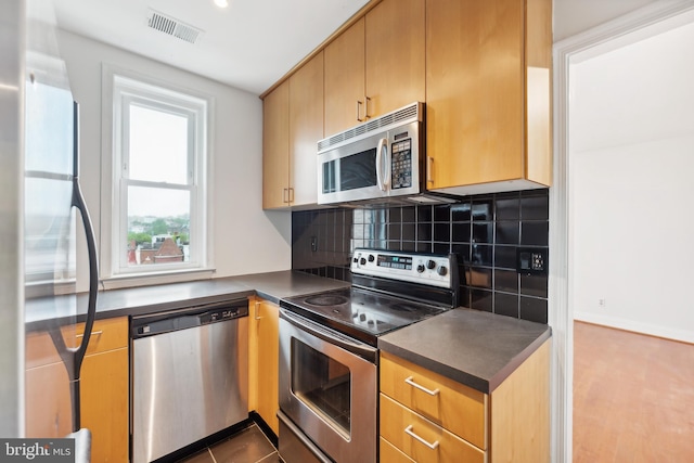 kitchen featuring appliances with stainless steel finishes and tasteful backsplash