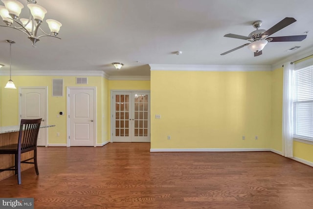 unfurnished room with dark wood-type flooring, french doors, ceiling fan with notable chandelier, ornamental molding, and a wealth of natural light