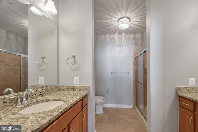 bathroom featuring tile patterned flooring, vanity, toilet, and a shower with door