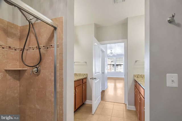 bathroom featuring tile patterned flooring, vanity, ceiling fan, and walk in shower