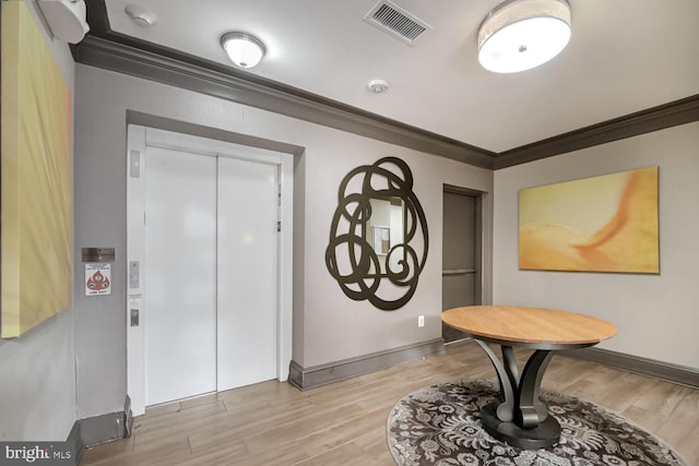 foyer entrance with ornamental molding and elevator