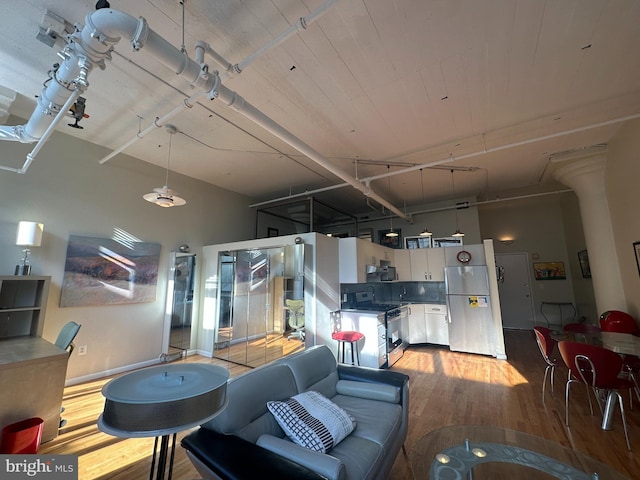 living room featuring light hardwood / wood-style floors and a high ceiling