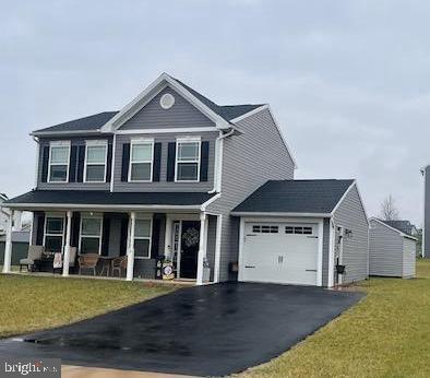 view of property featuring a front yard, a porch, and a garage