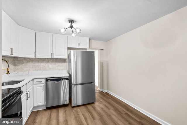 kitchen featuring white cabinets, appliances with stainless steel finishes, and light hardwood / wood-style flooring