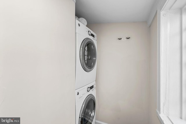 washroom featuring stacked washer and clothes dryer