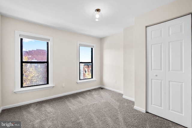 unfurnished bedroom with a closet, carpet floors, and multiple windows