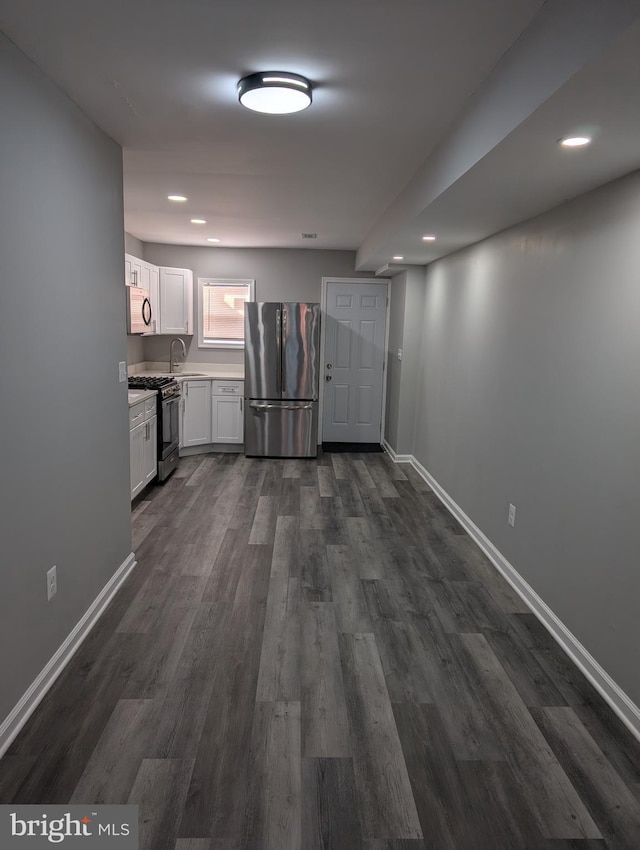 kitchen with sink, white cabinetry, stainless steel appliances, and dark wood-type flooring