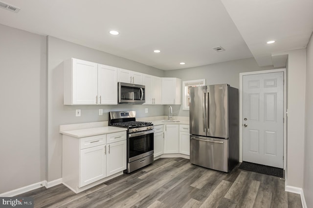 kitchen featuring white cabinetry, sink, stainless steel appliances, and dark hardwood / wood-style floors