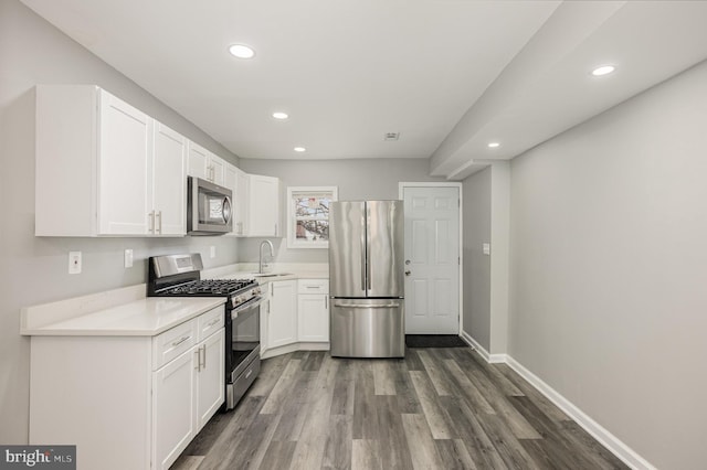 kitchen featuring dark wood-type flooring, sink, white cabinets, and stainless steel appliances