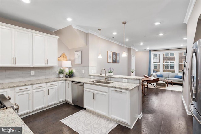 kitchen with kitchen peninsula, appliances with stainless steel finishes, white cabinetry, and sink