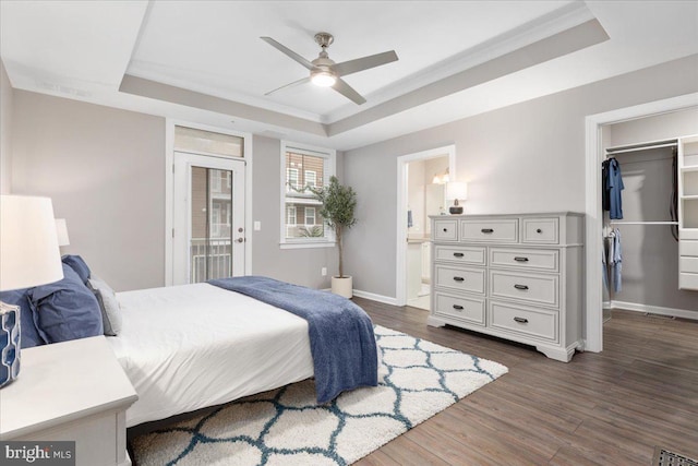 bedroom with a closet, a raised ceiling, ceiling fan, and dark hardwood / wood-style floors