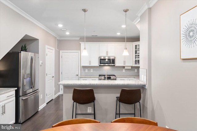 kitchen with light stone countertops, tasteful backsplash, stainless steel appliances, white cabinetry, and hanging light fixtures