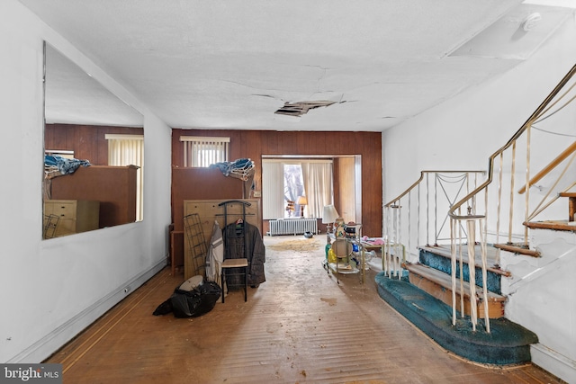 entryway featuring radiator heating unit, wooden walls, and hardwood / wood-style floors