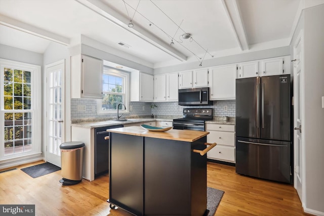 kitchen with a center island, sink, white cabinetry, and stainless steel appliances