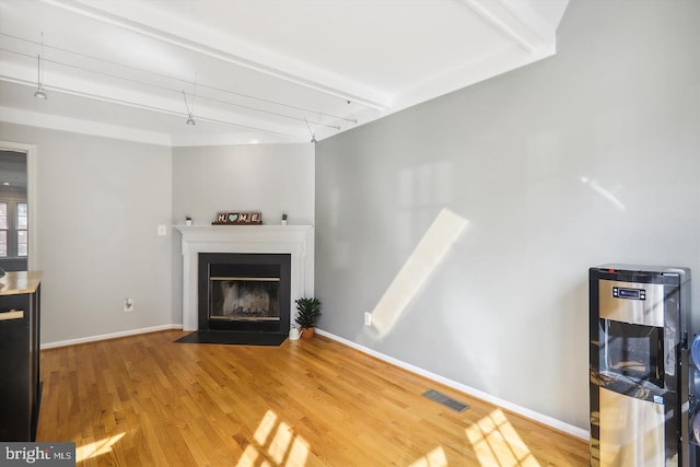 living room featuring beam ceiling and hardwood / wood-style floors