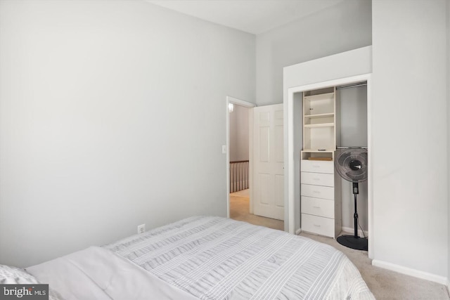 bedroom featuring light carpet and a closet