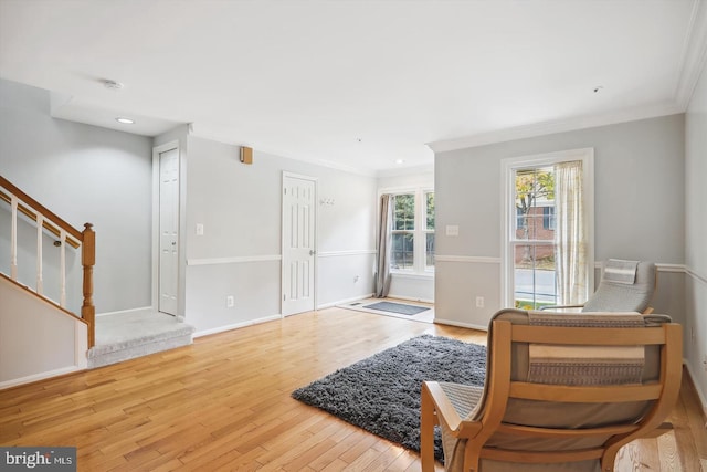 living area with light wood-type flooring and crown molding