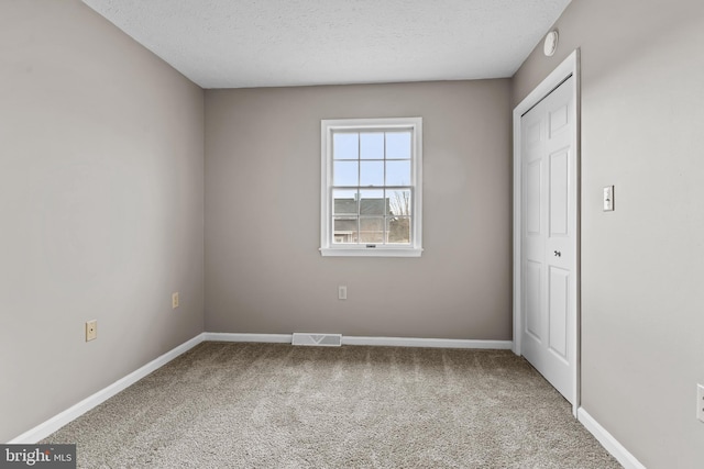 unfurnished bedroom with carpet flooring and a textured ceiling