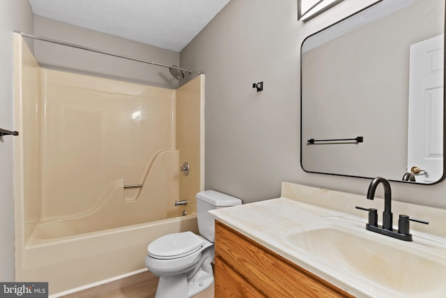 full bathroom featuring vanity, a textured ceiling, toilet, and washtub / shower combination