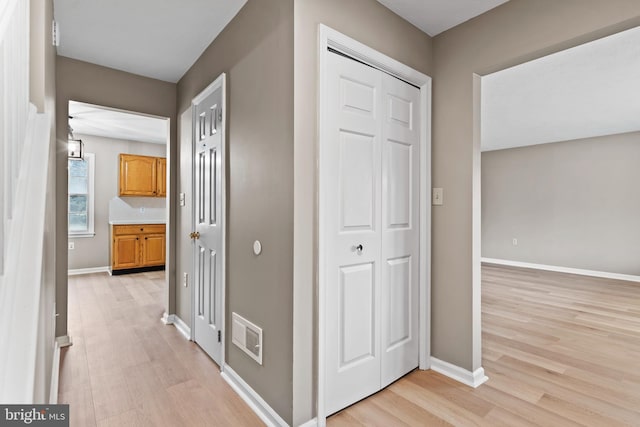 corridor with light hardwood / wood-style flooring