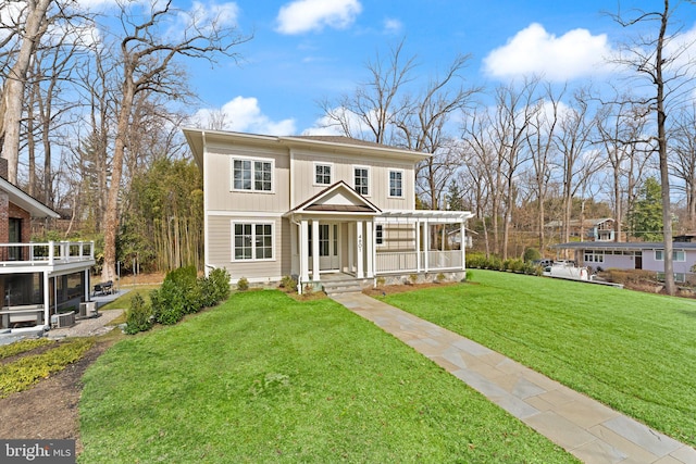 view of front of home with board and batten siding, a front yard, and a sunroom