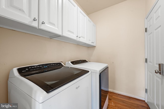 washroom featuring dark hardwood / wood-style flooring, cabinets, and independent washer and dryer