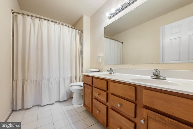 bathroom with toilet, vanity, and tile patterned floors