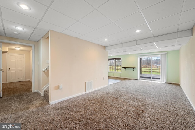 unfurnished living room with carpet flooring and a paneled ceiling