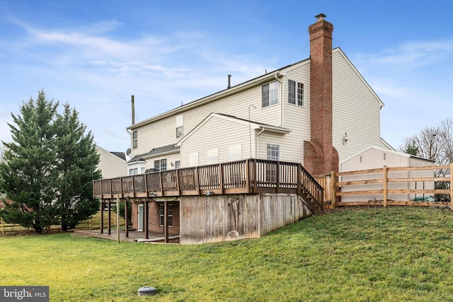 rear view of property with a lawn and a wooden deck