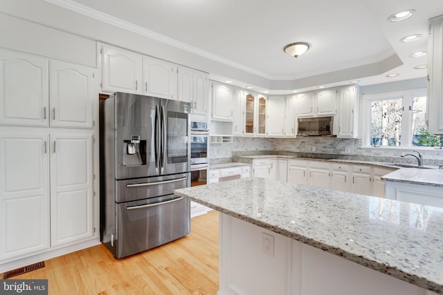 kitchen featuring white cabinets, stainless steel appliances, and light stone countertops