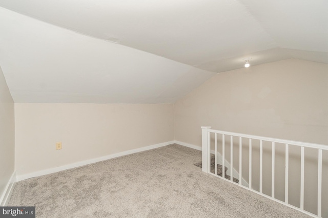 additional living space featuring vaulted ceiling, baseboards, and carpet floors