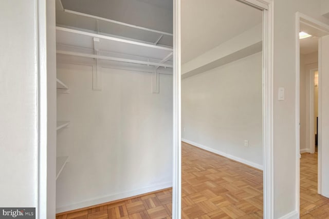 walk in closet with light parquet flooring