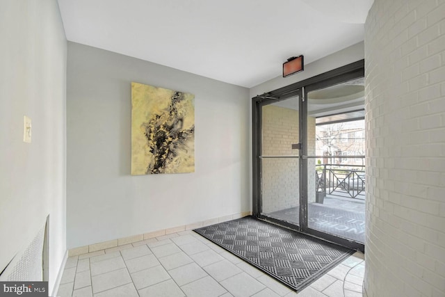 doorway to outside with light tile patterned floors