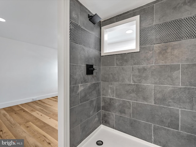 bathroom featuring wood-type flooring and tiled shower