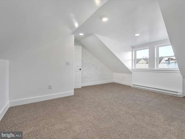 additional living space with carpet, a baseboard radiator, and vaulted ceiling