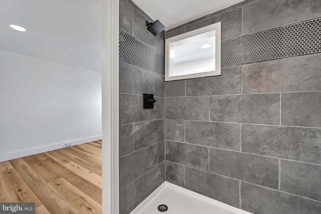 bathroom featuring hardwood / wood-style flooring and tiled shower