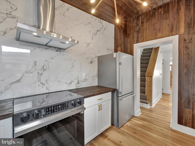 kitchen featuring appliances with stainless steel finishes, extractor fan, wooden ceiling, white cabinets, and butcher block countertops