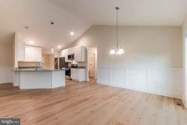 kitchen featuring white cabinets, appliances with stainless steel finishes, light wood-type flooring, and kitchen peninsula