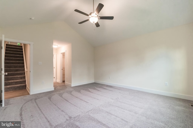 unfurnished bedroom with a spacious closet, ceiling fan, light colored carpet, vaulted ceiling, and a closet