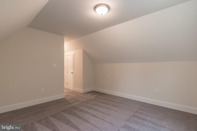 bonus room with carpet flooring and vaulted ceiling